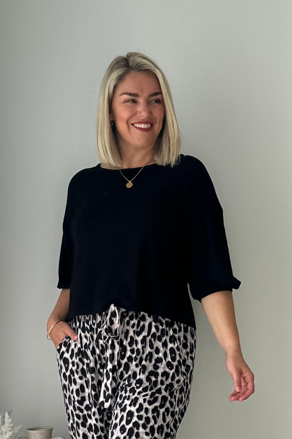 Lexi Bamboo Top in black styled with Alexa Pants in grey leopard, front view, model smiling.