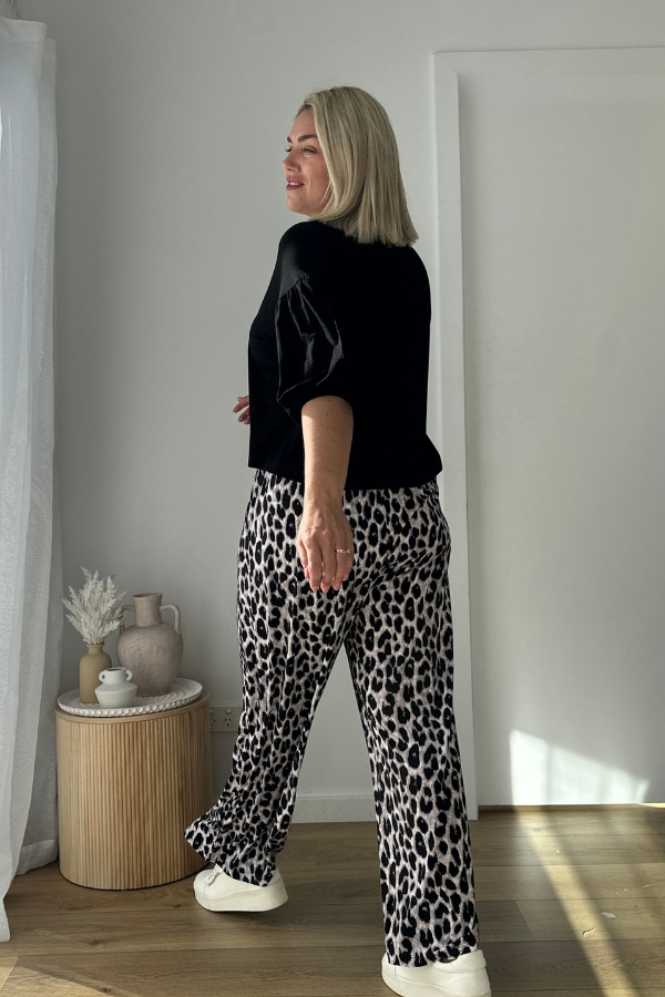 Side angle of woman wearing the Lexi Bamboo Top in black with Alexa Pants in grey leopard print.